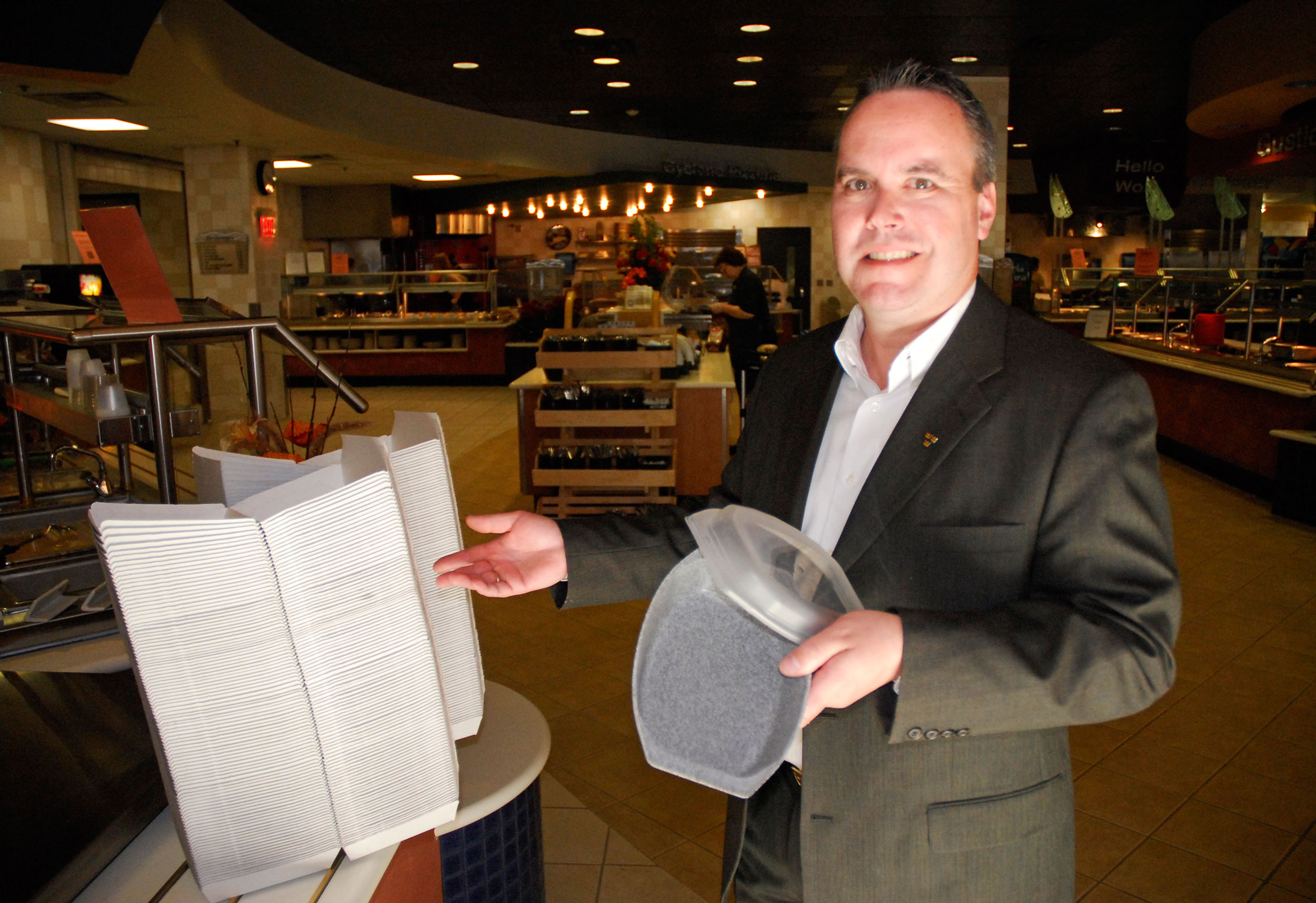 Director of Dining Services Steve Kjellgren holds the new Market Place Tupperware, which is meant to reduce use of the cardboard boxes.