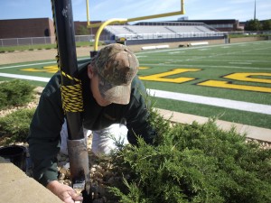 Steve Douglas, Lead Painter for Physical Plant, paints a new post in Hollingsworth Field to finish sprucing it up for the Homecoming game and festivities.  By: Alex Messenger.