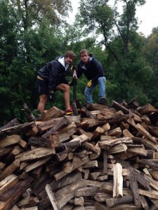 Senior Joe Renier (left) and Sophomore Nate Hanson (right) posed for a photo atop the pile of wood they were stacking during a recent volunteer activity the Cross Country team participated in at Seven Mile Creek Park. Submitted