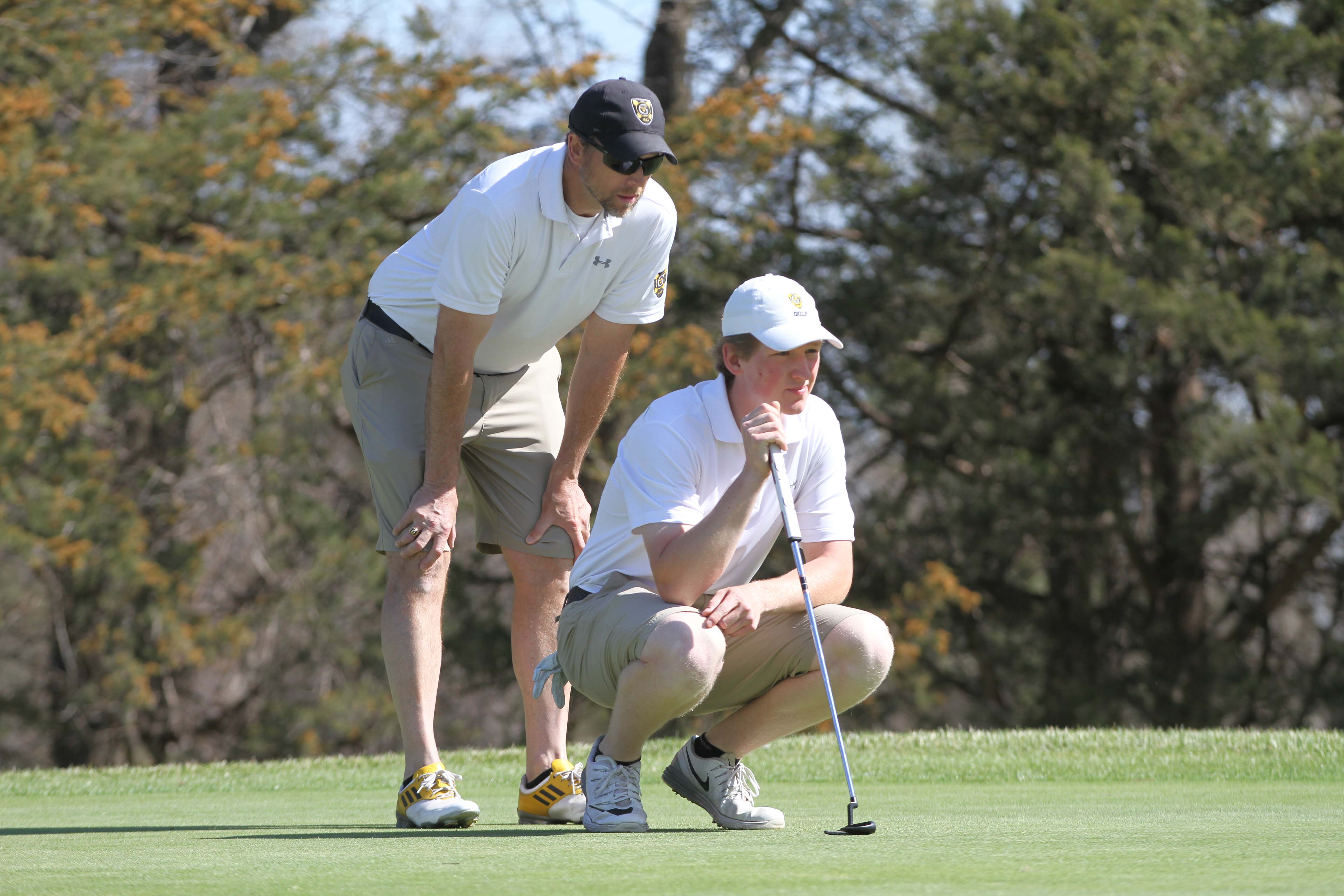 Sophomore Max Ullan and Head Coach Scott Moe analyze the green to prepare for a putt. The Gusties finished eighth out of 17 teams this past weekend at the Twin Cities Invite.