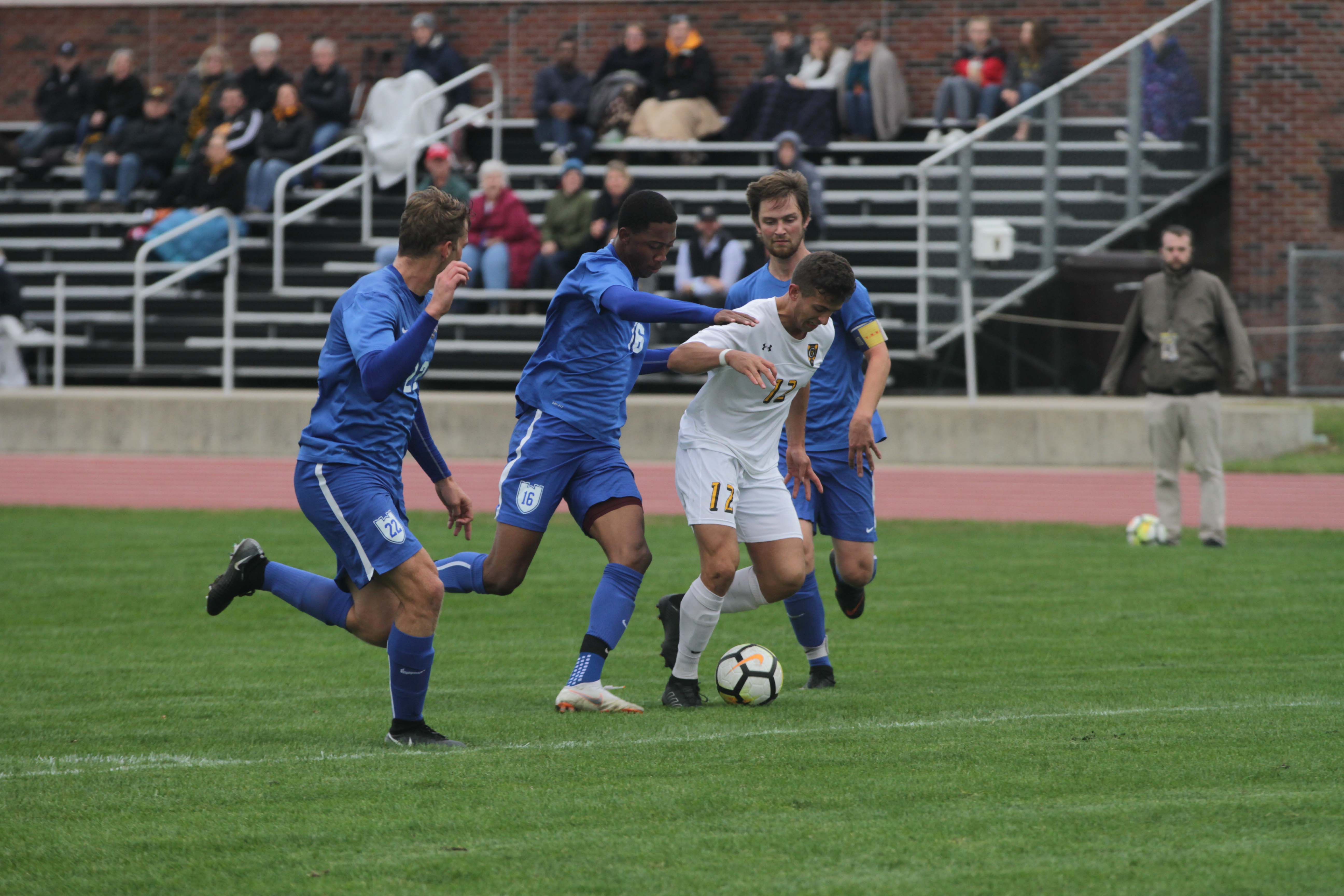 Senior Arthur Parens dribbles past St. Scholastica defenders during a game Oct. 2. The Gusties are undefeated at home this season after six games played.