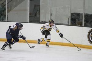 Junior Kristen Cash retrieves the puck for the Gusties during a match against Bethel last season. The team has started off its season with a record of 1-0-1.