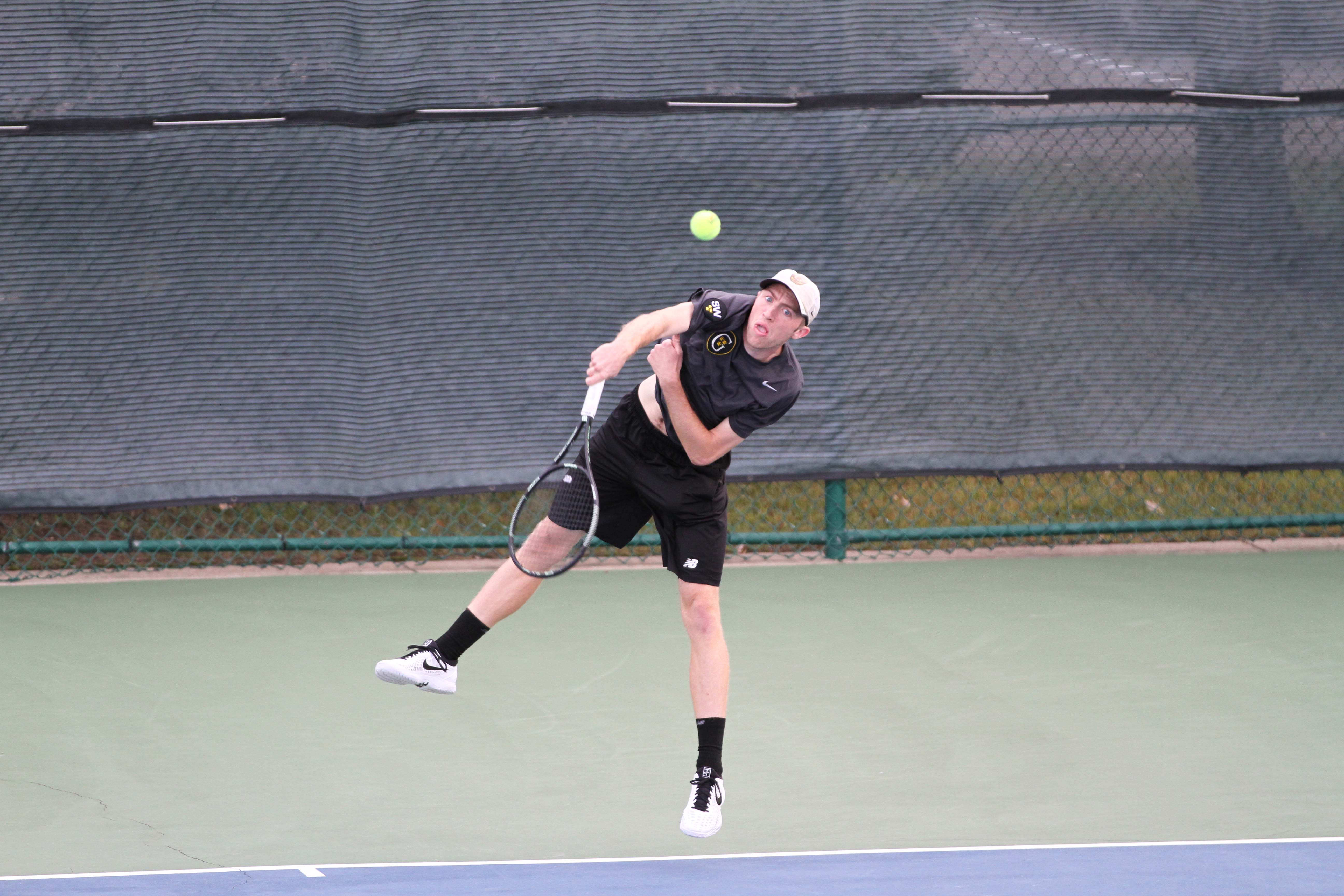Senior Chase Johnson serves a ball during a match. The team got its second consecutive consolation title this past weekend at the ITA Indoor Championships.