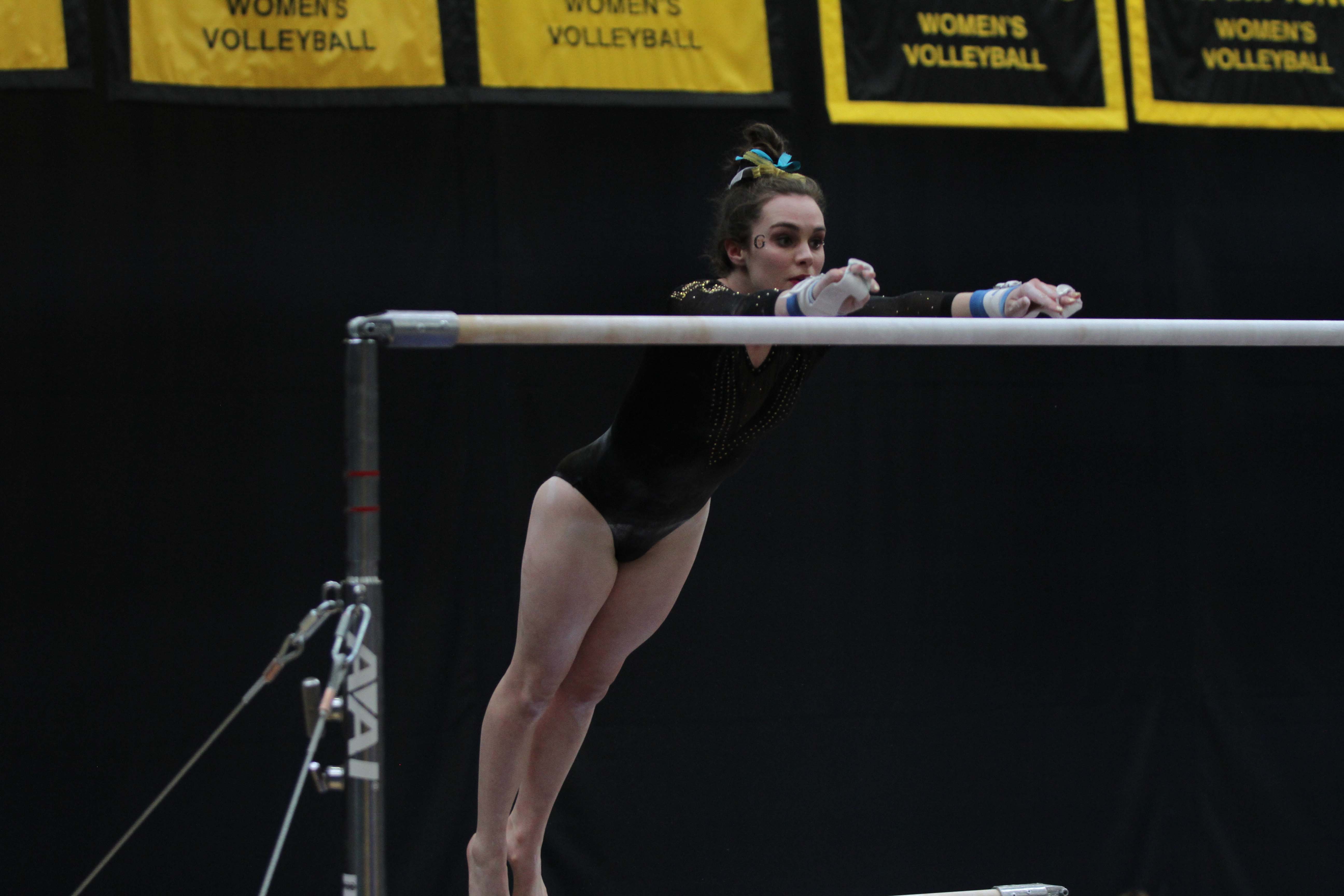 Junior Grace Arnold competes in the uneven bars at the WIAC/NCGA West Regional Meet March 9. The team had some strong individual performances that day and placed sixth out of eight teams.