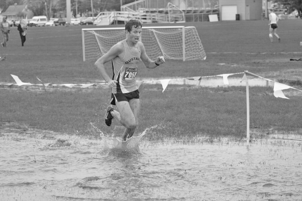 Sophomore Matthew Payne tries to keep his pace as he treks through deep puddles that formed all over the course at the Dan Huston Invitational in Waverly, Iowa.