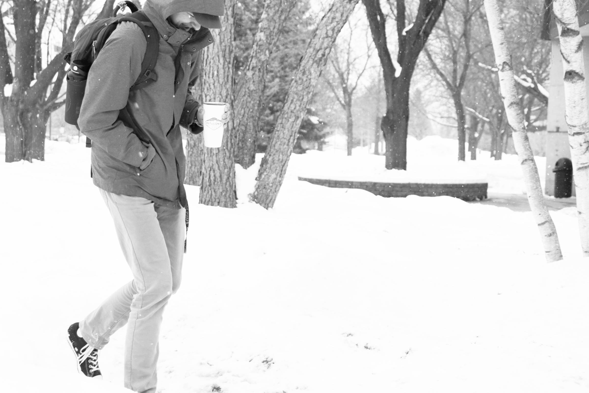 A student walking in front of the Jackson Campus Center during a heavy snowfall.