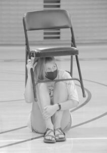 A hypnotized Gustie takes shelter under a folding chair.