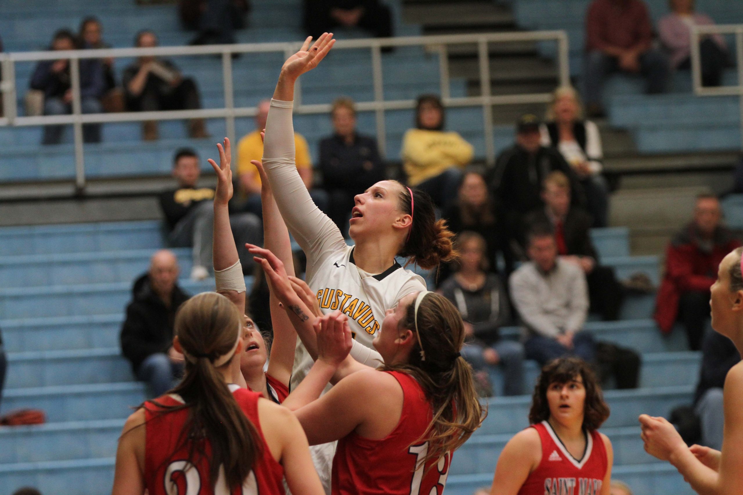 Sophomore Paige Richert attempts to tip the ball into the basket under pressure from three St. Mary’s opponents.